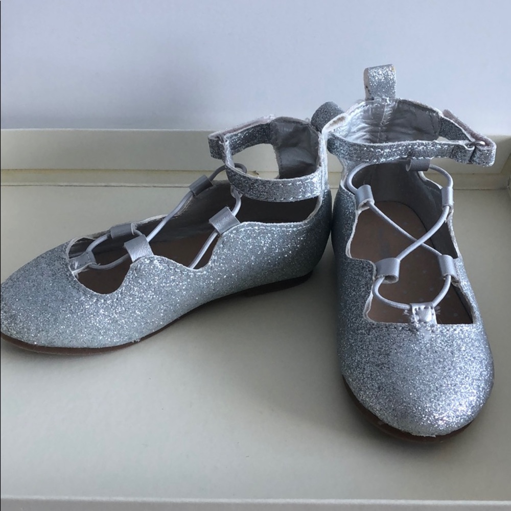 Silver shiny dressy sandals with strap closure.